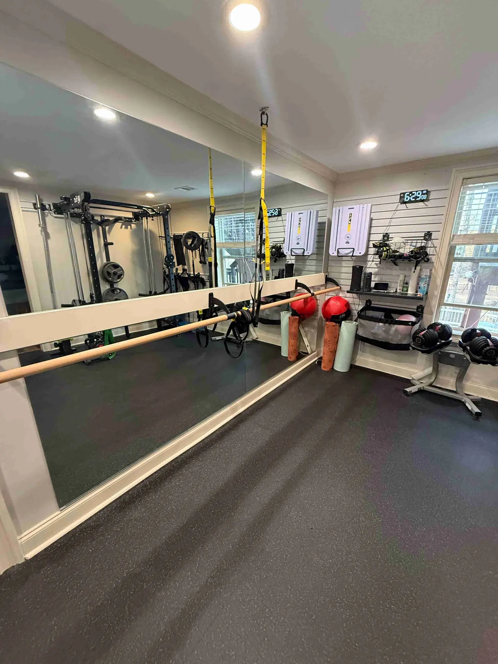 Fully equipped gym with squat rack, mirrors, and free weights